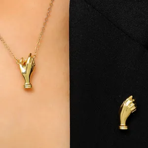 Detailansicht der kreativen goldfarbenen Handstrauß-Brosche und Kette am schwarzen Anzug
