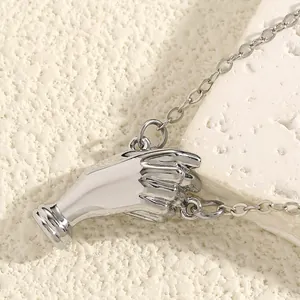 Close-up detail of a silver hand-shaped bouquet brooch showing polished metallic texture