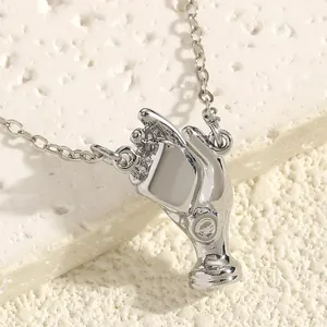 Detailed macro shot of a polished silver hand-shaped pendant showcasing its artistic design