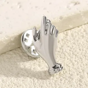 Close-up detail of a creative silver hand-shaped brooch for unique floral styling