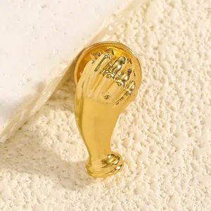Makrodetail einer klassischen goldfarbenen Brosche in Handform mit poliertem Finish