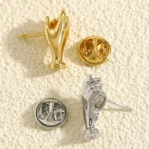 Detailansicht der kreativen handförmigen Bouquet-Broschen in Gold und Silber