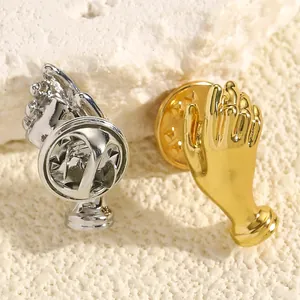 Detailansicht kreativer handförmiger Straußbroschen in poliertem Gold- und Silberfinish.