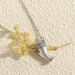 Detailed view of creative silver hand brooch holding a beautiful dried flower bouquet.