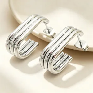Detail shot of polished silver triple-layer linear stainless steel oval stud earrings