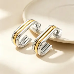 Close-up view of elegant multi-layered oval stainless steel earrings in gold and silver