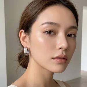 Detailed view of multi-layer oval stainless steel hoop earrings on Asian female model