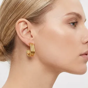 Detailed close-up showing stylish 18K gold-plated multi-layer oval hoop earrings on a model.