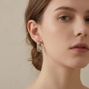 Detail shot of 18K gold plated stainless steel multilayer oval hoop earring on model.