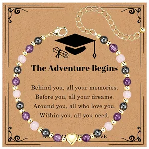 Detail of graduation bracelet with natural stones and gold heart charm on message card