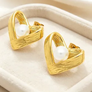 Detailansicht eleganter goldener Herzohrringe mit Perlen in einer luxuriösen Schmuckbox