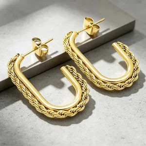 Close-up of golden stainless steel U-shaped earrings with a twisted rope texture