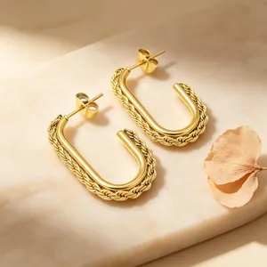 Macro shot of elegant golden stainless steel U-shaped earrings with twisted rope texture