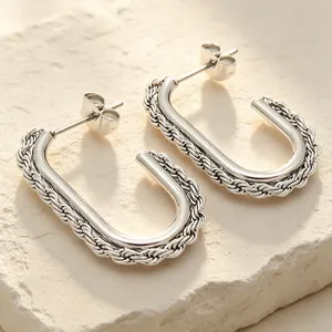 Macro view of silver-toned twist rope texture on oval stainless steel earrings