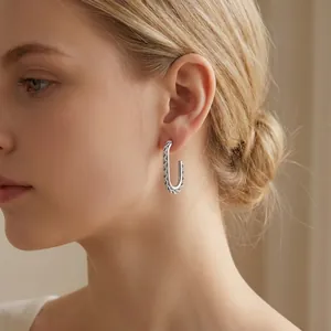 Elegant stainless steel square twist hoop earrings shown on a female model close-up view