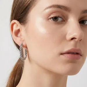 Close-up of a model wearing silver twisted rope stainless steel hoop earrings