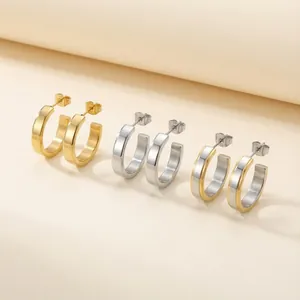 Detailed view of minimalist stainless steel C-shaped hoop earrings in three finishes