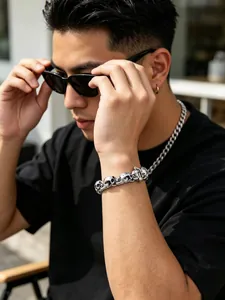 Close-up detail of men's titanium steel bracelet featuring intricately carved skull links