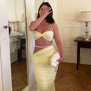Elegantes gelbes zweiteiliges Set mit Perlenbesatz-Crop-Top und passendem langem Rock-Detail.