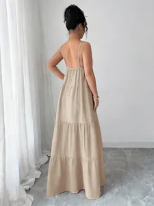 Rear view of an elegant beige tiered maxi sundress with thin adjustable spaghetti straps.
