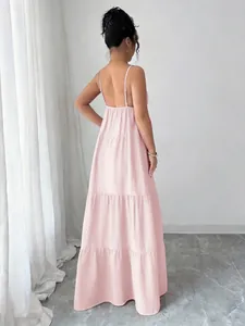 Elegant backless light pink tiered maxi dress with spaghetti straps shown from the back