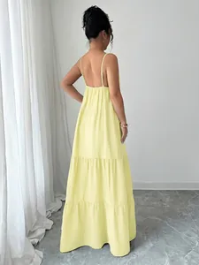 Back view of a yellow tiered spaghetti strap maxi dress with an elegant backless design