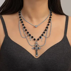 Vista dettagliata di una collana a croce gotica a più strati con perle nere