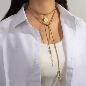 Primo piano di una collana a strati in stile etnico vintage con ciondolo a moneta turchese