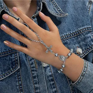 Vista dettagliata di un bracciale a mano in stile western con croce e eleganti perle grigie