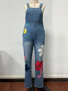 Detailed view of women's blue denim overalls featuring vibrant multi-colored floral prints