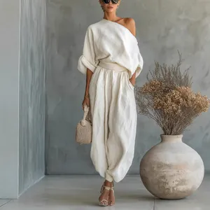Chic white cotton linen set with one-shoulder top and loose lantern pants outfit.