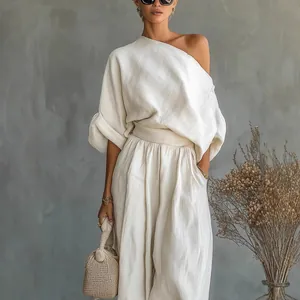 Elegant off-white cotton linen set with one-shoulder top and loose lantern trousers.