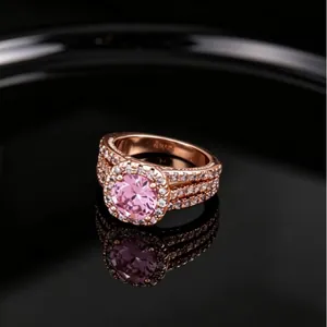 Bague luxueuse à trois rangs en or rose avec zircon rose sur fond noir brillant