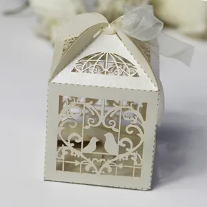 Close-up detail of an elegant laser-cut bird favor box with a delicate white ribbon