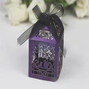 Detail of purple laser-cut birdcage wedding candy box with elegant black ribbon bow