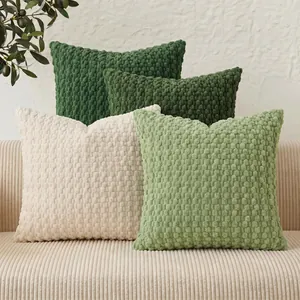 Decorative solid color bubble grain textured throw pillow covers displayed on a corduroy sofa