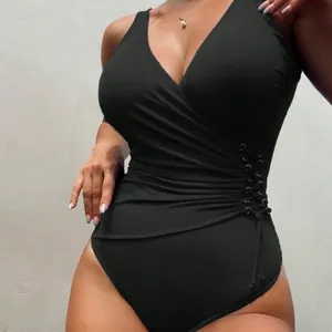 Elegant black one-piece swimsuit featuring V-neck, ruched waist and side lace-up details