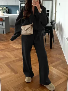 Femme portant un ensemble de détente noir élégant de deux pièces avec veste zippée et pantalon large
