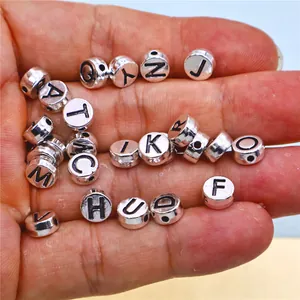 Macro view of DIY silver alloy alphabet beads featuring all 26 capital letters charms.