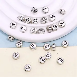 Detail view of 26 silver alloy alphabet beads with black engraved capital letters for DIY crafts