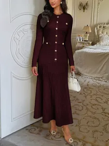 Elegant burgundy long-sleeved knit maxi dress featuring decorative gold buttons on a model