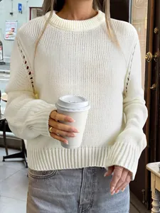 Détail rapproché d'un pull en maille blanche pour femme dans un café de rue élégant