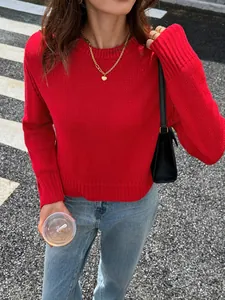 Détail d'un pull en maille rouge vif à manches longues pour le style d'automne femme