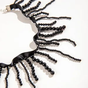 Detailed macro shot of a Gothic black beaded fringe necklace featuring a smooth satin ribbon.