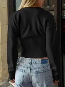 Women's black long sleeve knit sweater featuring a ribbed waist and slim fit back view.