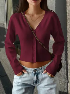 Close-up of burgundy V-neck knit cardigan with button details and ribbed waist