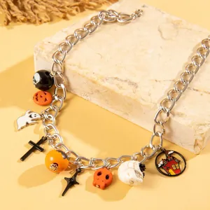 Close-up detail of a vintage gothic Halloween necklace with pumpkin and ghost charms.