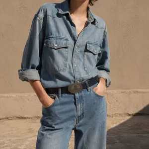 Stylish women's vintage waist belt featuring a large engraved alloy buckle on blue denim