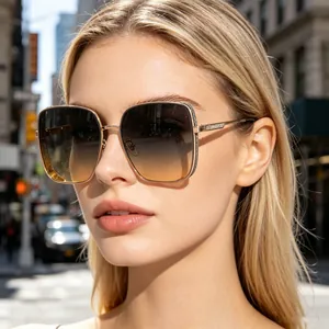 Close-up of oversized square sunglasses with rhinestone gold frames and gradient lenses.