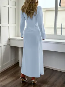 Vista posteriore di un abito a camicia a maniche lunghe azzurro in ambiente sobrio.